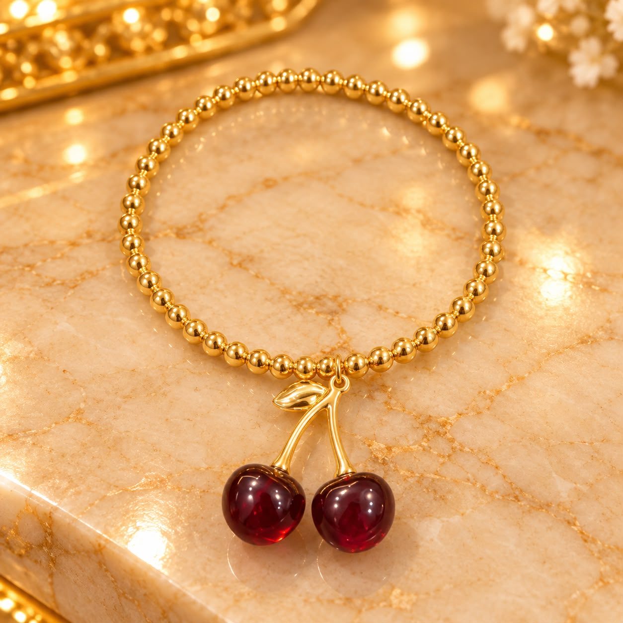 Pulsera dorada con charm de cereza